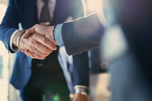 Poignée de main ferme entre deux professionnels en costume pour conclure un accord.